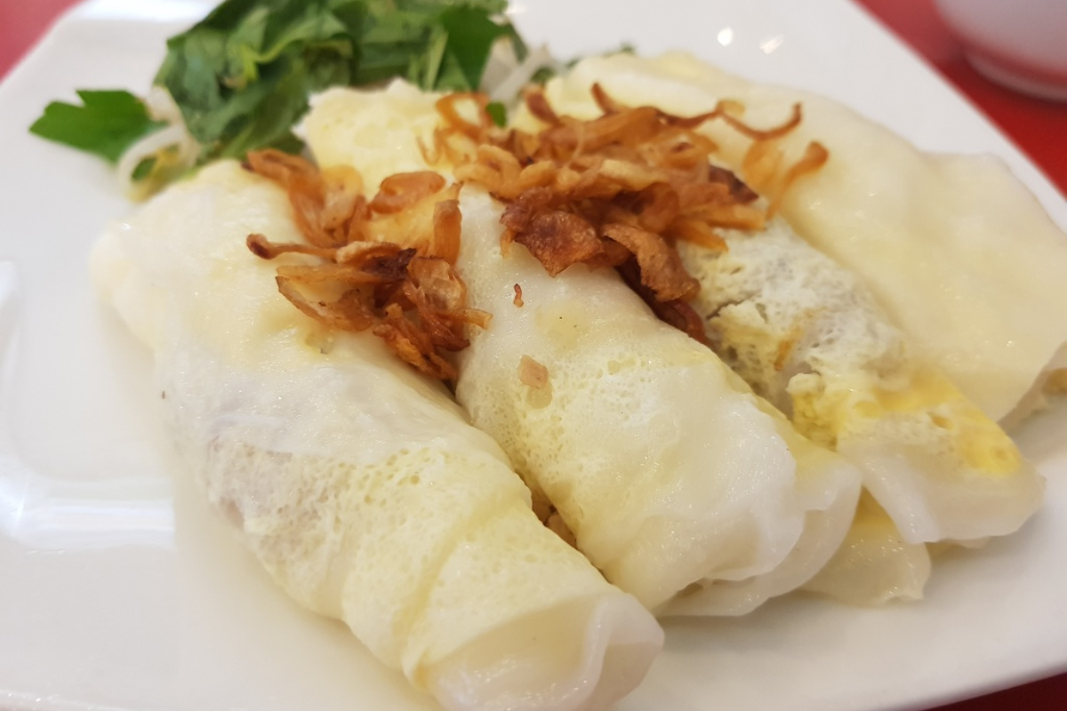 Thin rice pancakes filled with egg and pork, served with dipping sauce
